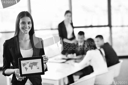 Image of business woman with her staff in background at office