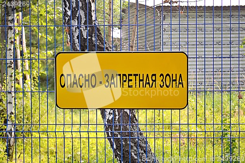 Image of the plate on a fence "It is dangerous - a prohibited zone"