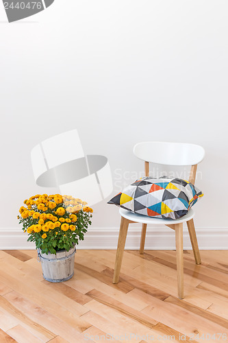 Image of Orange chrysanthemums bright cushion on a chair
