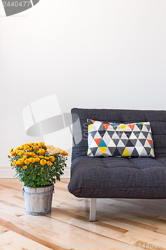 Image of Orange chrysanthemums and sofa with bright cushion