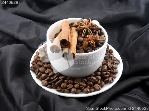 Image of cup of cofee with cinnamon in black background