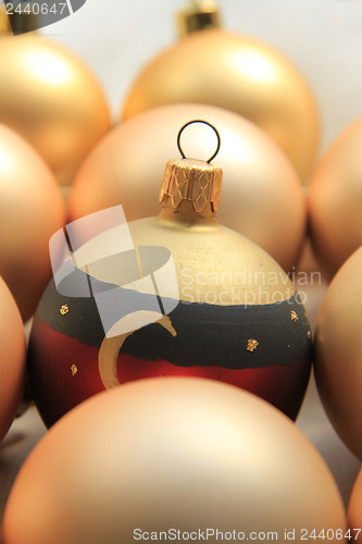 Image of Red ornament on a pile of golden ornaments