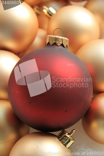 Image of Red ornament on a pile of golden ornaments