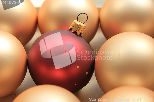Image of Red ornament on a pile of golden ornaments