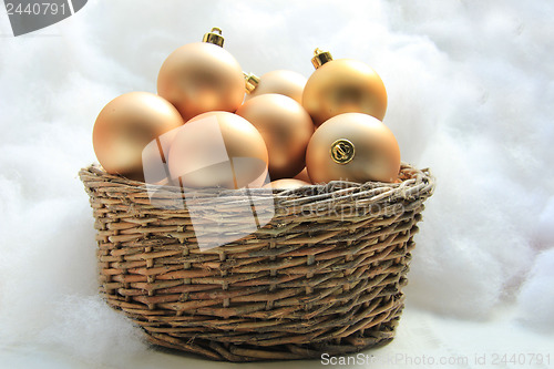 Image of Golden Christmas ornaments in a wicker basket