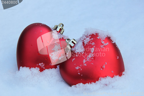 Image of Two red hearts in the snow