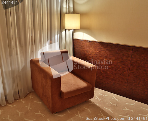 Image of brown armchair and floor lamp