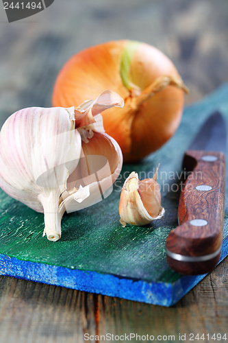 Image of Garlic and onions on a cutting board.