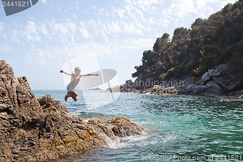 Image of Young boy jumping into the sea