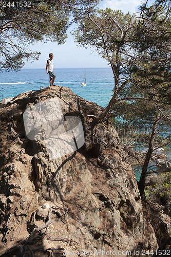 Image of Young  boy on rocky coastline