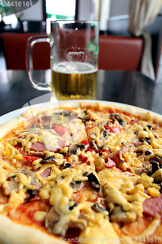 Image of tasty appetizing pizza and glass of beer