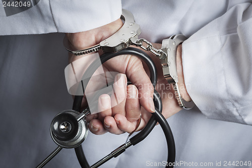 Image of Female Doctor or Nurse In Handcuffs Holding Stethoscope