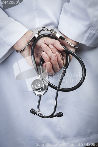 Image of Female Doctor or Nurse In Handcuffs Holding Stethoscope