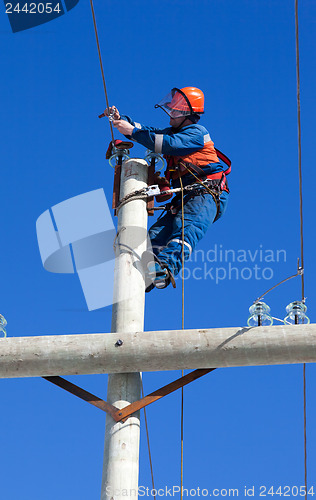 Image of electrician working on top of an electricity pylon
