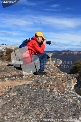 Image of Photographer taking photos of mountain landscape