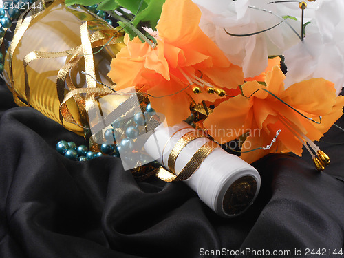 Image of bottle of champagne and flowers. festive arrangement with sparkling wine and flowers