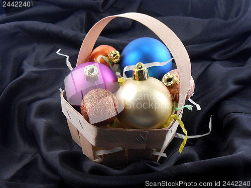 Image of Christmas toy balls on black material background