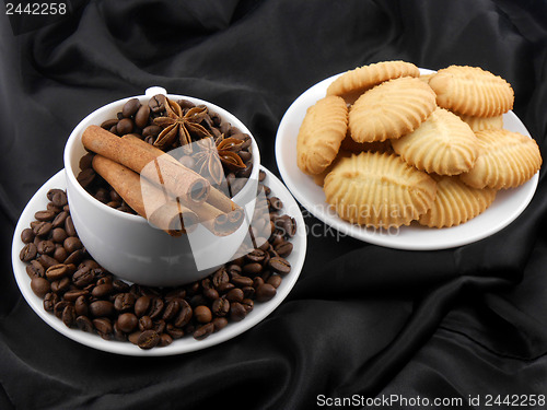 Image of Cup of coffee with cinnamon, cake and coffee beans