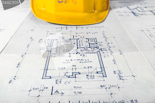 Image of Yellow helmet of an engineer with plans