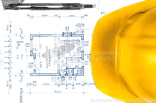 Image of Yellow helmet of an engineer with plans