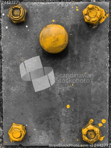 Image of Yellow screws on grey metal plate