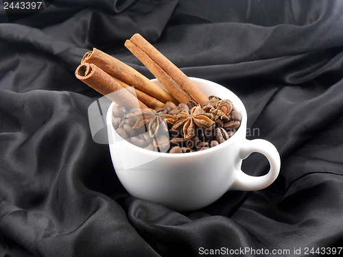 Image of Composition with white cup of coffee, coffee beans and cinnamon