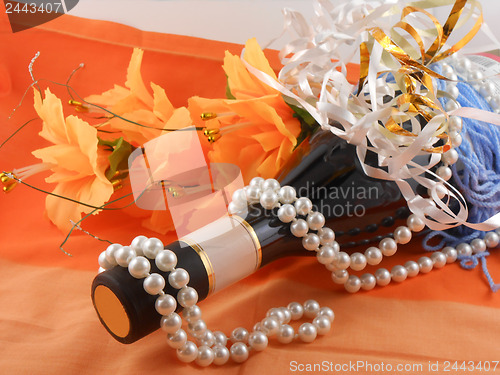 Image of flowers, white diamonds and a champagne bottle