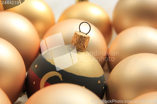 Image of Red ornament on a pile of golden ornaments