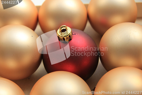 Image of Red ornament on a pile of golden ornaments