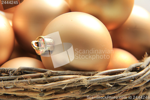 Image of Golden Christmas ornaments in a wicker basket