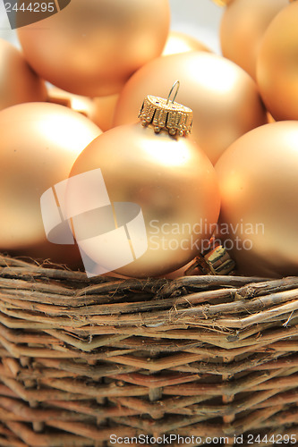 Image of Golden Christmas ornaments in a wicker basket