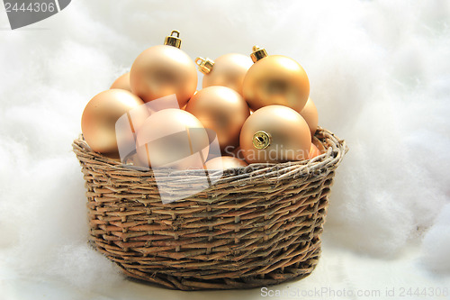 Image of Golden Christmas ornaments in a wicker basket