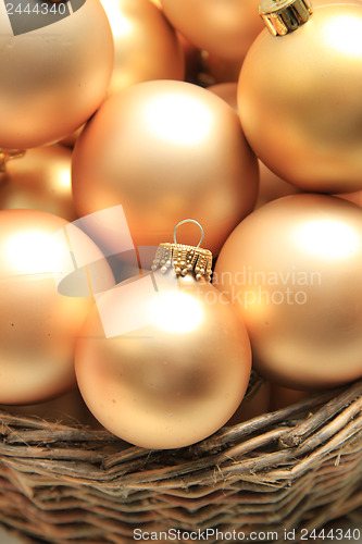 Image of Golden Christmas ornaments in a wicker basket