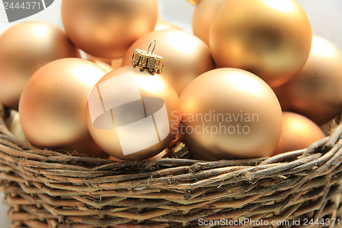 Image of Golden Christmas ornaments in a wicker basket