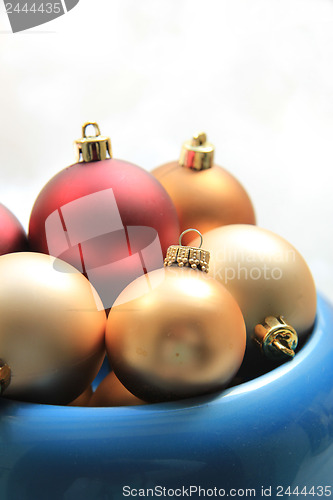 Image of red and golden christmas ornaments in a blue bowl