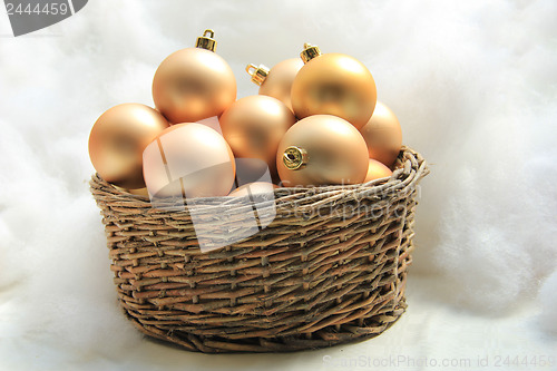 Image of Golden Christmas ornaments in a wicker basket