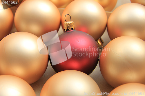 Image of Red ornament on a pile of golden ornaments