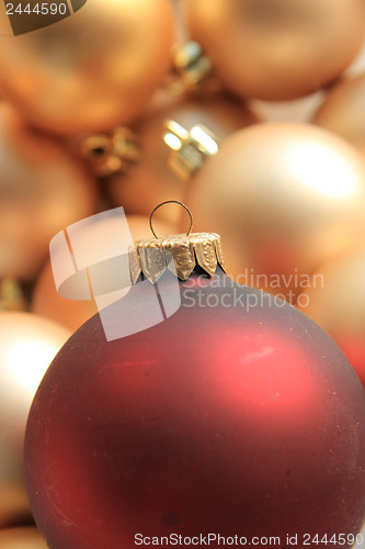 Image of Red ornament on a pile of golden ornaments