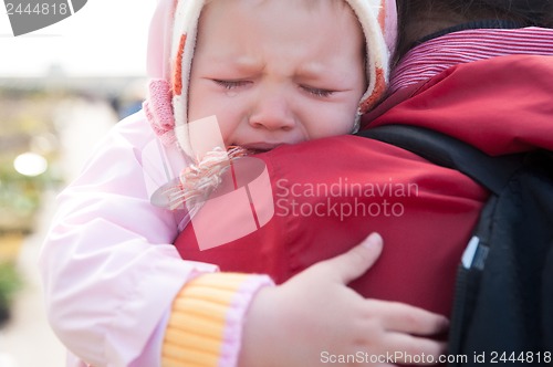 Image of crying baby on mother shoulder