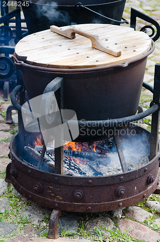 Image of old pot for cooking over a campfire, close-up. 