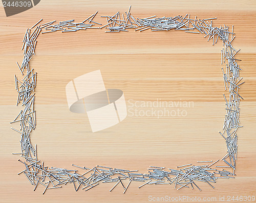 Image of Metal nails border on wood