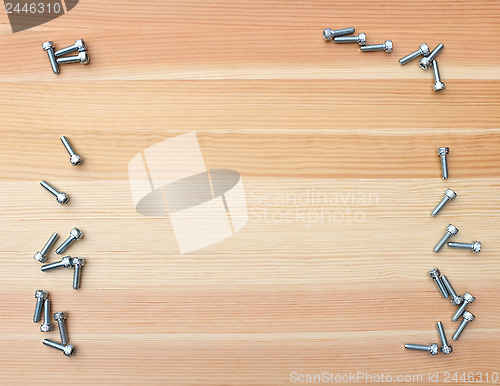 Image of Socket head bolts as border on wood