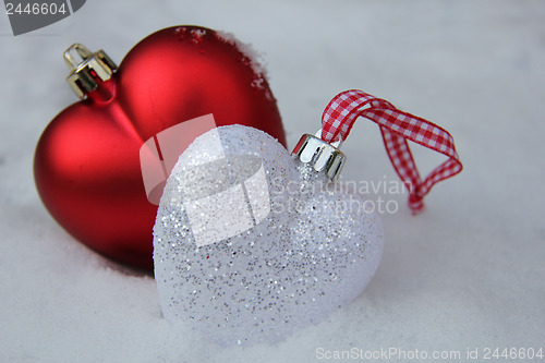 Image of Red and white heart ornaments in snow
