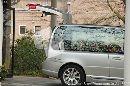 Image of Grey hearse with sympathy flowers