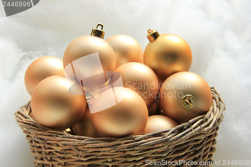 Image of Golden Christmas ornaments in a wicker basket