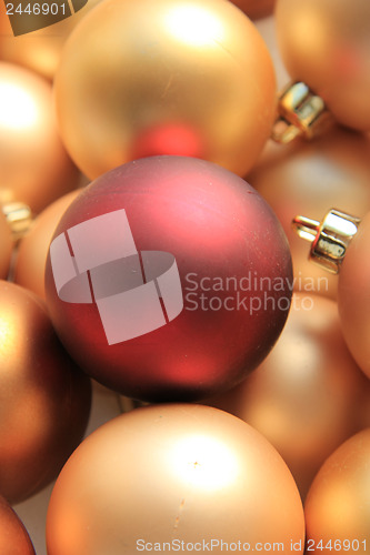 Image of Red ornament on a pile of golden ornaments
