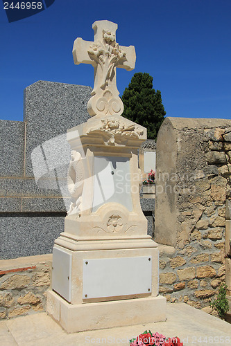Image of Tombstone with cross ornament at a French cemetery
