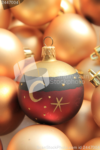 Image of Red ornament on a pile of golden ornaments