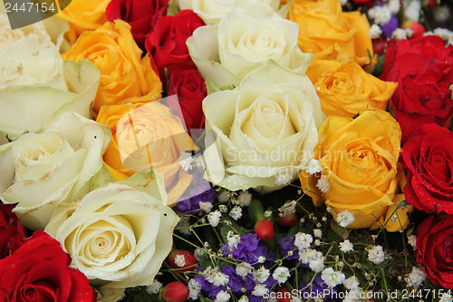 Image of yellow, white and red roses in a wedding arrangement