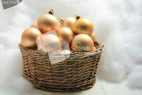 Image of Golden Christmas ornaments in a wicker basket